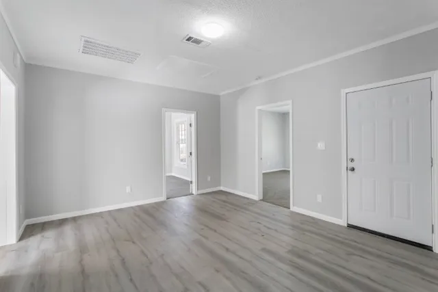 a view of an empty room with wooden floor