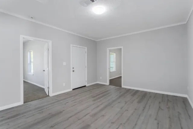 a view of an empty room with wooden floor