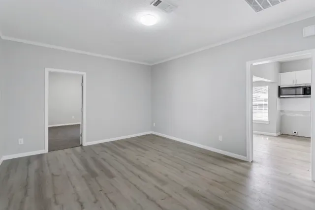 a view of empty room with wooden floor