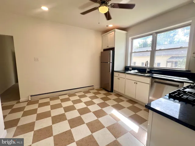 a kitchen with a sink a refrigerator a window and stainless steel appliances