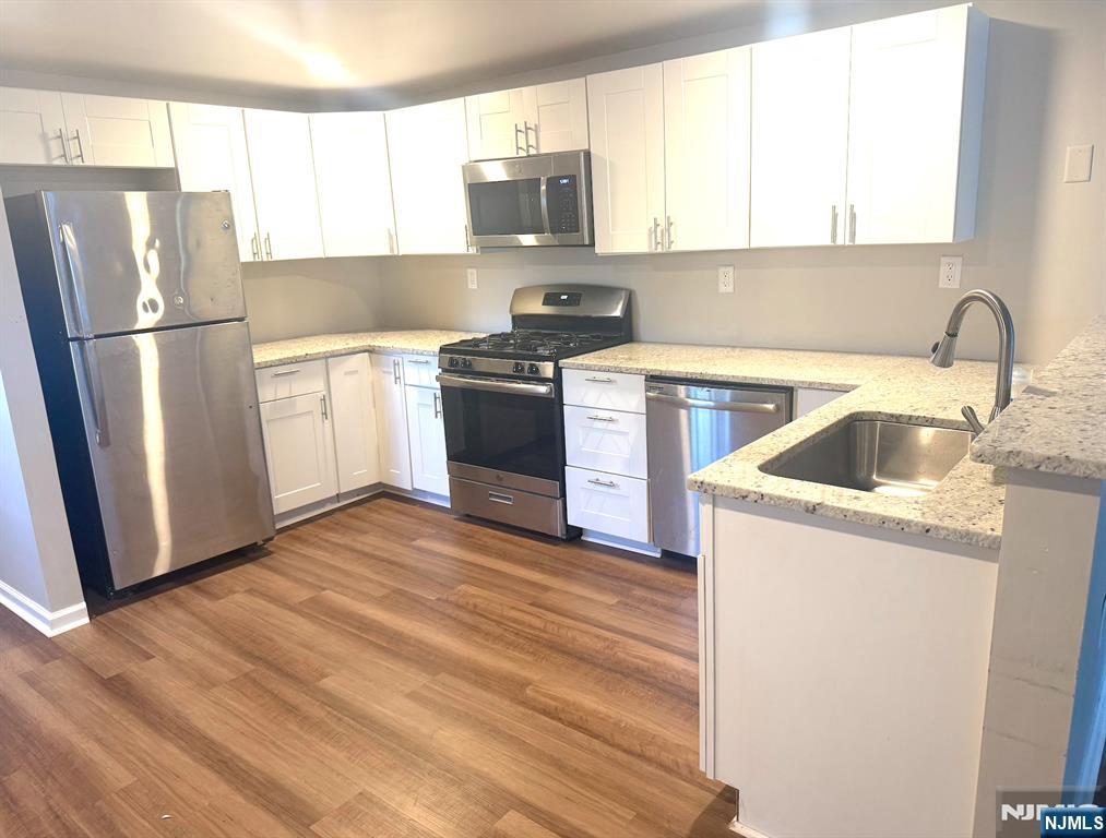 314 3rd Street Dunellen, NJ 08812 - Photo 8 of 15 a kitchen with a refrigerator sink and wooden floor