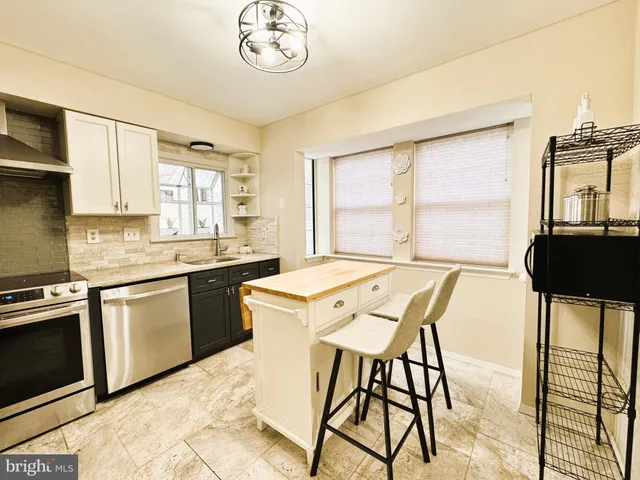 a kitchen with a stove a sink a dining table and chairs