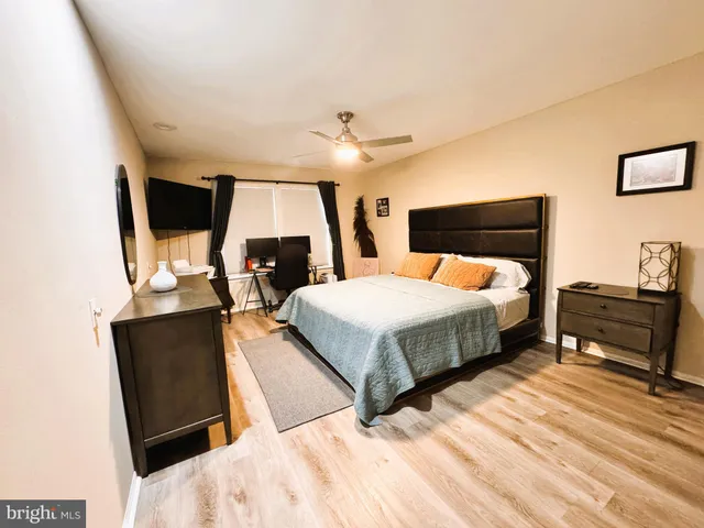 a bedroom with a bed a flat screen tv and a couch