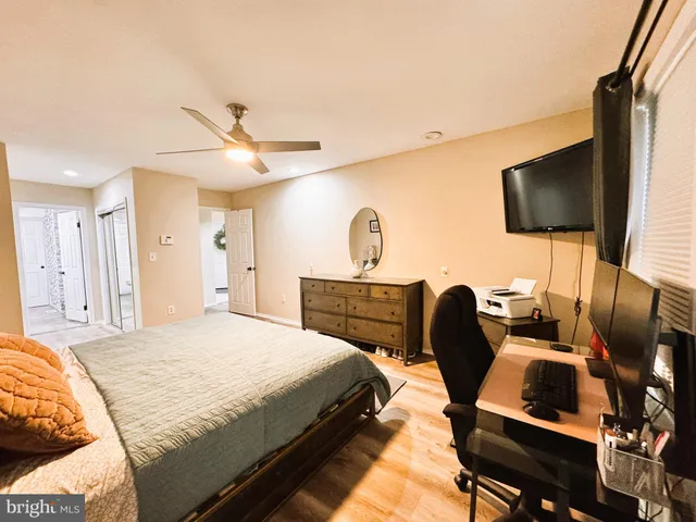 a view of a hallway with wooden floor and a bathroom