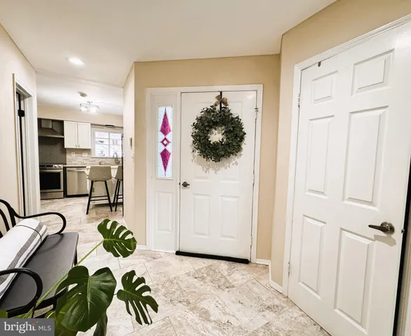 a living room with furniture kitchen view and a chandelier