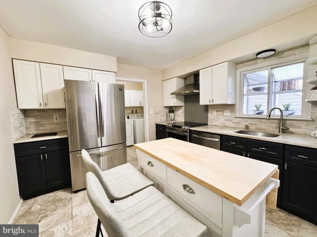 a kitchen with a table chairs sink and cabinets