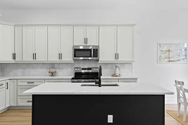 a kitchen with stainless steel appliances a sink dishwasher a stove and a microwave