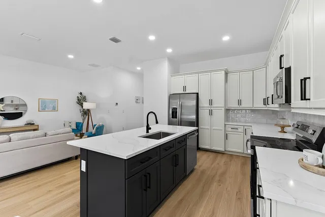 a kitchen that has a sink a stove and chairs