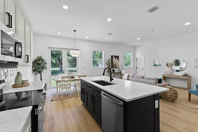 a kitchen with granite countertop a sink stove and cabinets