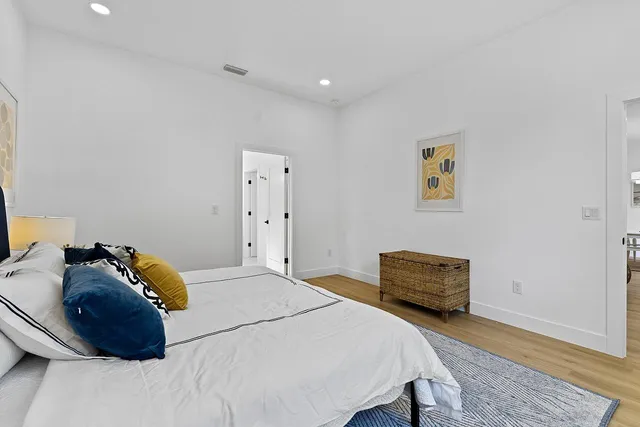 a bedroom with a bed and a lamp on dresser