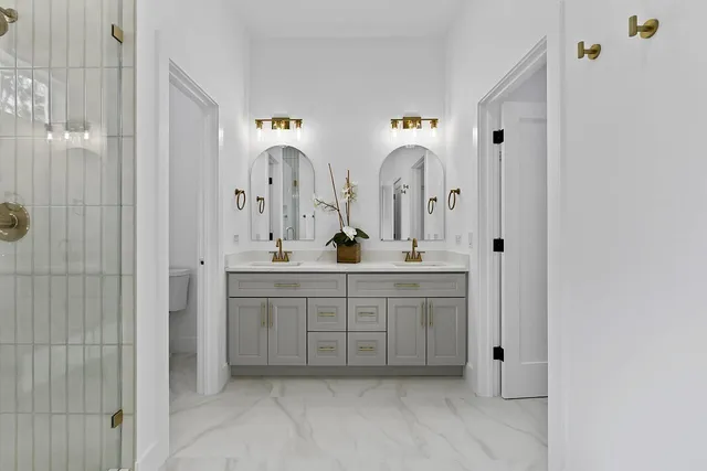 a bathroom with double vanity sink and mirror