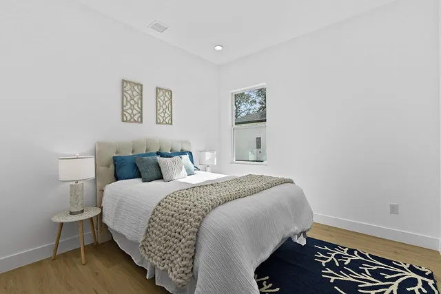 a bedroom with a bed and wooden floor