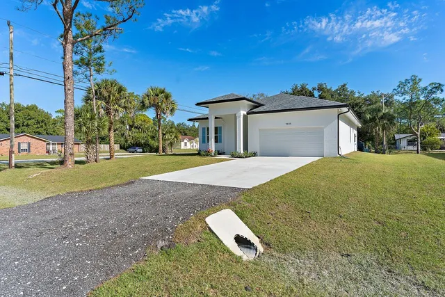 a view of a house with a yard and garage