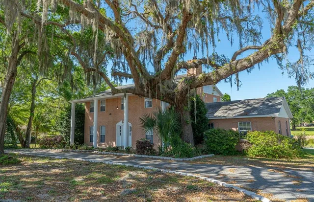 a view of a house with a tree and yard