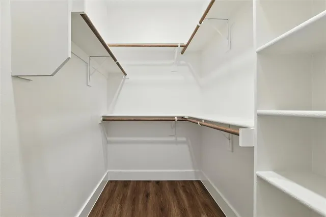 a view of walk in closet with empty racks
