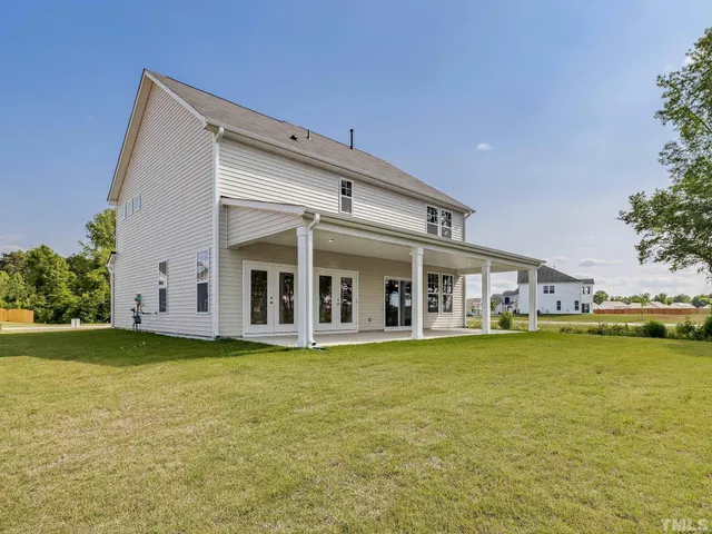 a view of a house with a big yard and potted plants