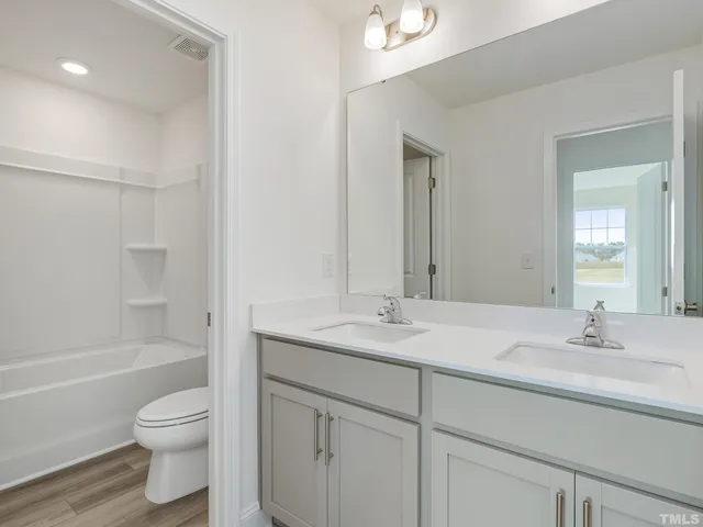 a bathroom with a granite countertop sink a toilet and a bathtub