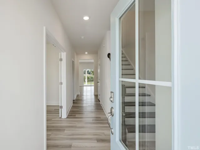 a hallway with wooden floor and windows