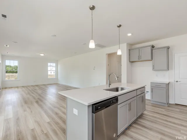 a kitchen with a sink chandelier and wooden floor