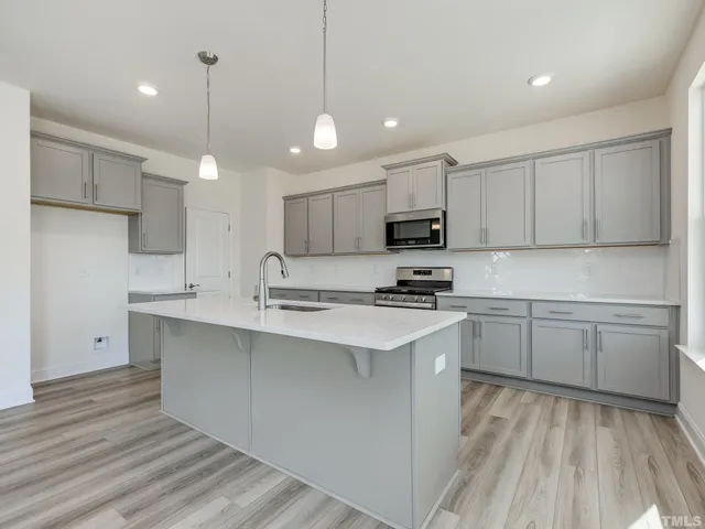 a kitchen with kitchen island a sink stainless steel appliances and cabinets