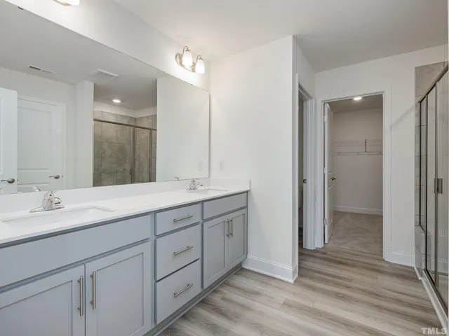 a bathroom with double vanity sink and a mirror