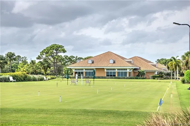 a front view of a house with swimming pool and green space