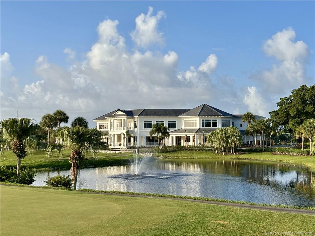 Undisclosed Address Stuart, FL 34997 - Photo 7 of 20 a front view of a house with a yard lake and outdoor seating