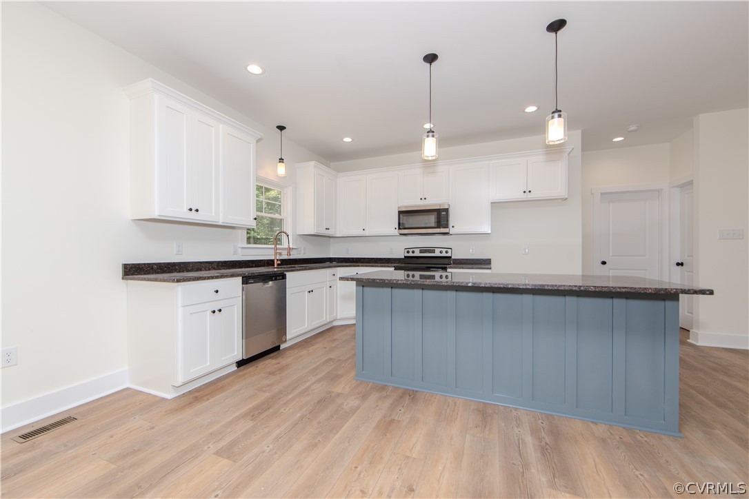 4243 Three Bridge Road Powhatan, VA 23139 - Photo 14 of 32 a kitchen with stainless steel appliances granite countertop a sink a stove and white cabinets with wooden floor