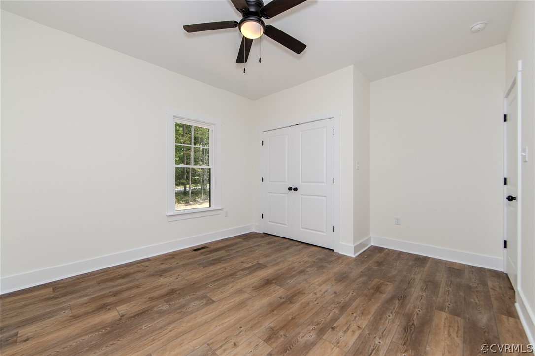 4243 Three Bridge Road Powhatan, VA 23139 - Photo 21 of 32 an empty room with wooden floor ceiling fan and windows