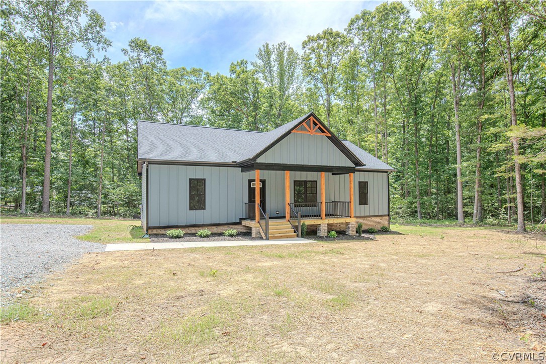 4243 Three Bridge Road Powhatan, VA 23139 - Photo 3 of 32 a front view of a house with a yard covered with trees