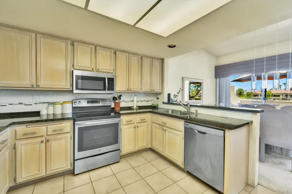 a kitchen with granite countertop a sink and a wooden cabinets