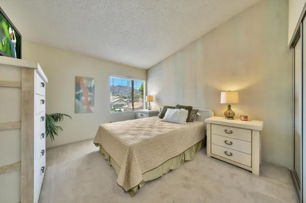 a spacious bedroom with a bed and a chandelier