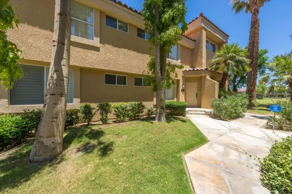 a view of a house with a yard and pathway