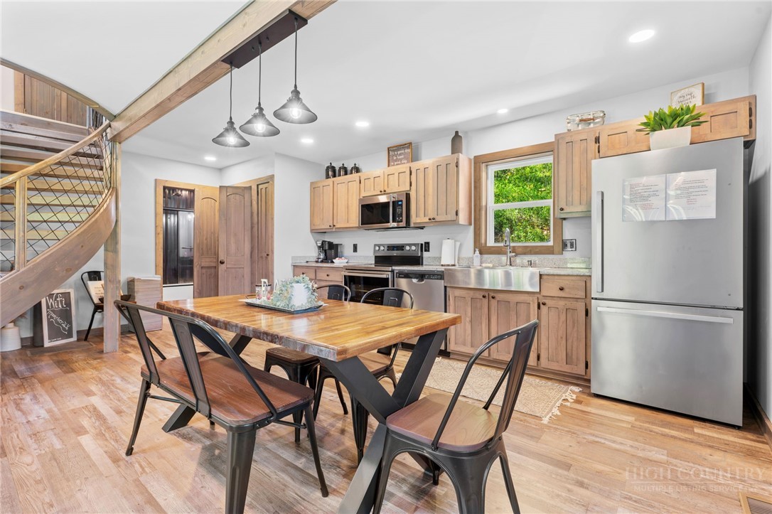 634-636 Watauga River Road Sugar Grove, NC 28679 - Photo 40 of 50 a kitchen with stainless steel appliances a dining table chairs refrigerator and microwave