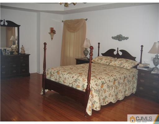 5 West Hill Road Colonia, NJ 07067 - Photo 6 of 7 a bed sitting in a bedroom next to a window with wooden floor