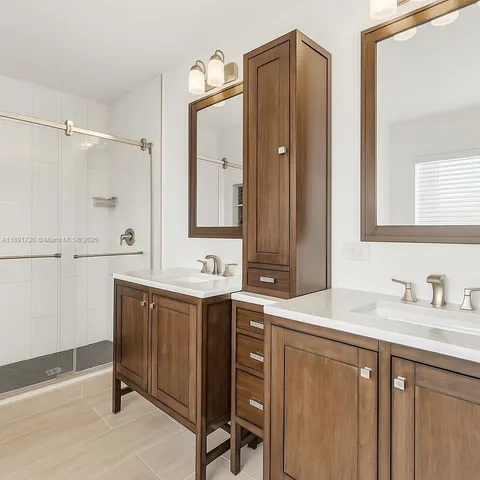 a bathroom with a sink shower and a mirror