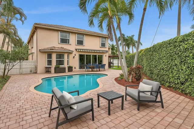 a view of a house with backyard and sitting area