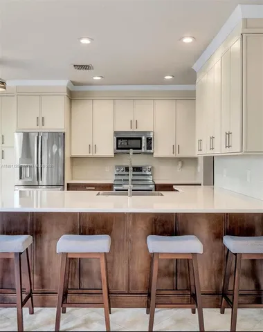 a kitchen with cabinets and chairs in it