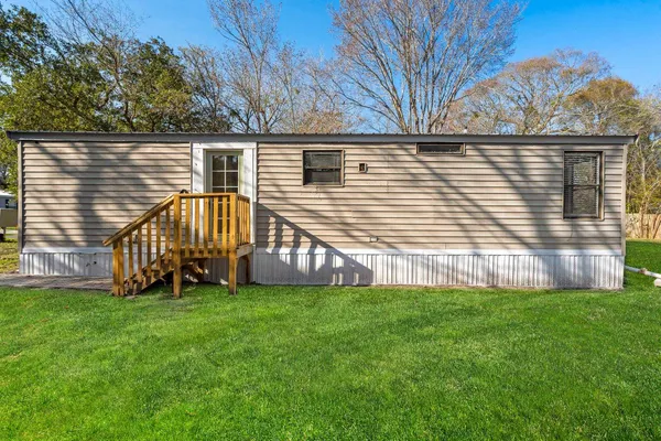 a view of a house with a yard and a deck