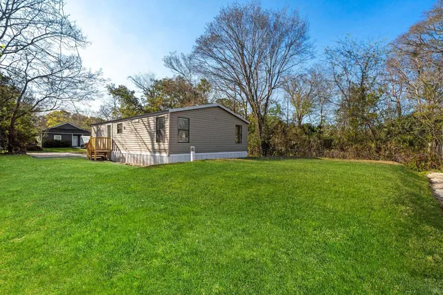 a view of a house with backyard and a tree