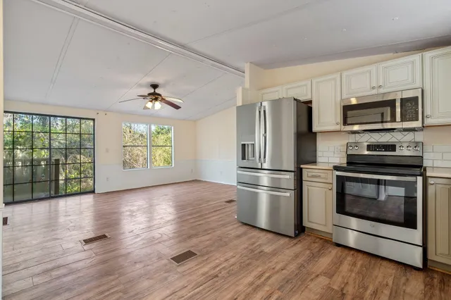 a kitchen with stainless steel appliances granite countertop a refrigerator microwave and stove