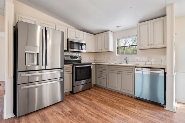 a kitchen with stainless steel appliances granite countertop a refrigerator sink and stove