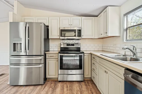 a kitchen with stainless steel appliances a refrigerator sink and microwave