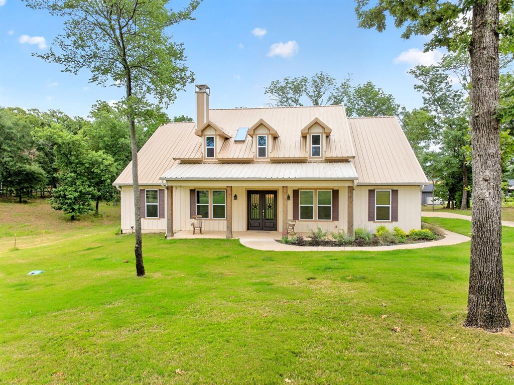5230 Esquire Estates Road Mabank, TX 75156 - Photo 2 of 39 Cream-colored exterior featuring a prominent metal roof and three dormer windows
