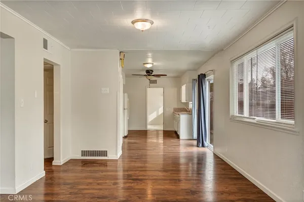 a view of a hallway with wooden floor and a window