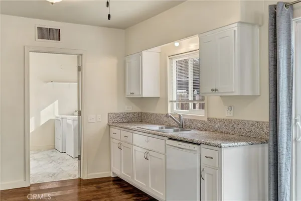 a kitchen with stainless steel appliances granite countertop a sink and a granite counter tops with white cabinets