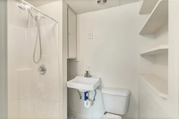 a bathroom with a sink a toilet and shower