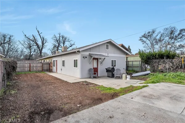a view of a house with backyard and chairs