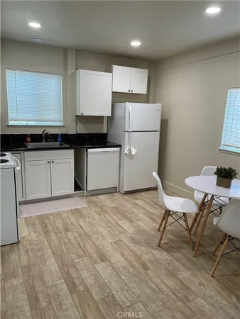 a kitchen with a sink cabinets and wooden floor