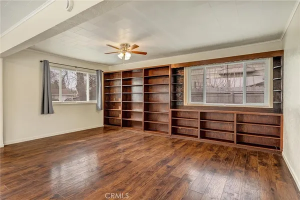 a view of an empty room with a window and wooden floor